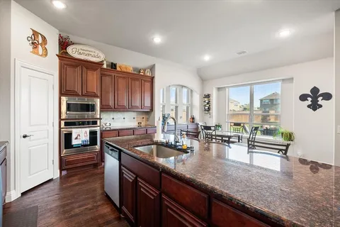 a kitchen with stainless steel appliances granite countertop a stove refrigerator and cabinets
