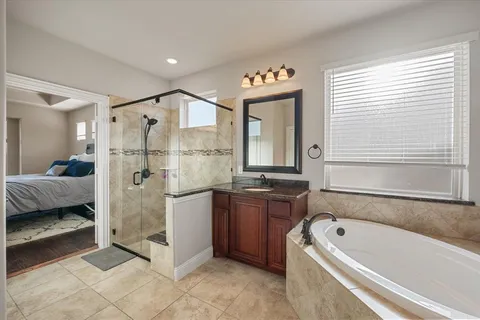 a bathroom with a tub sink and mirror