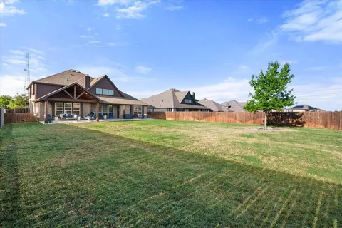a view of a house with a big yard potted plants and large tree