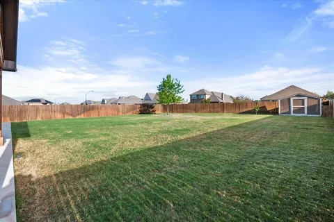 a view of a big house with a big yard and large trees