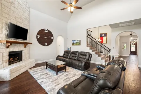 a living room with furniture a flat screen tv and a fireplace