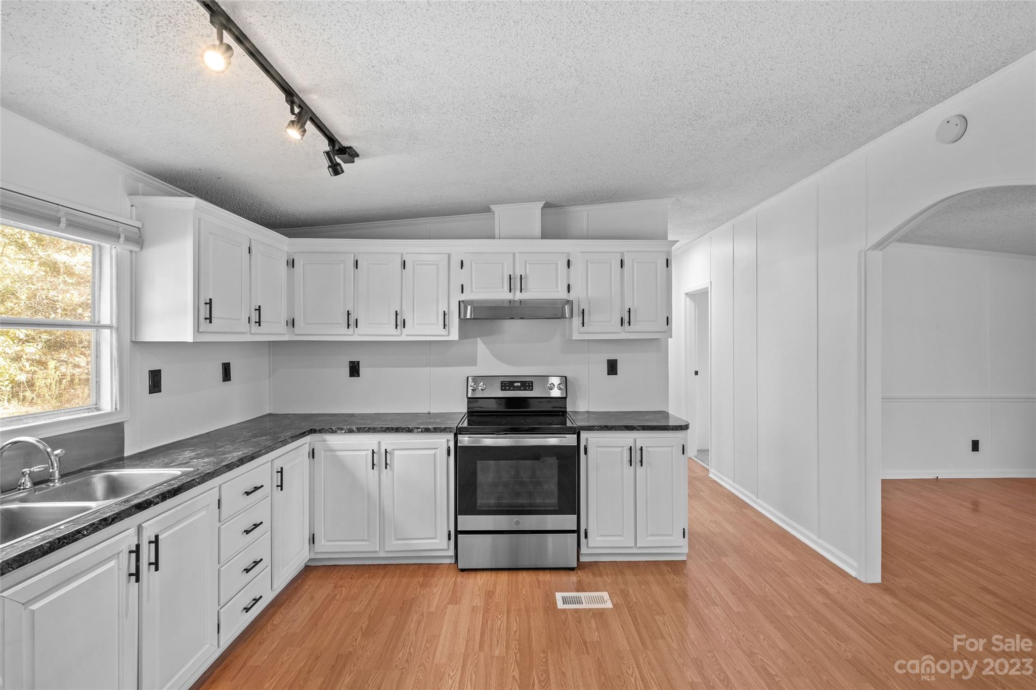 11341 Flowes Store Road Midland, NC 28107 - Photo 11 of 23 a kitchen with cabinets wooden floor and stainless steel appliances