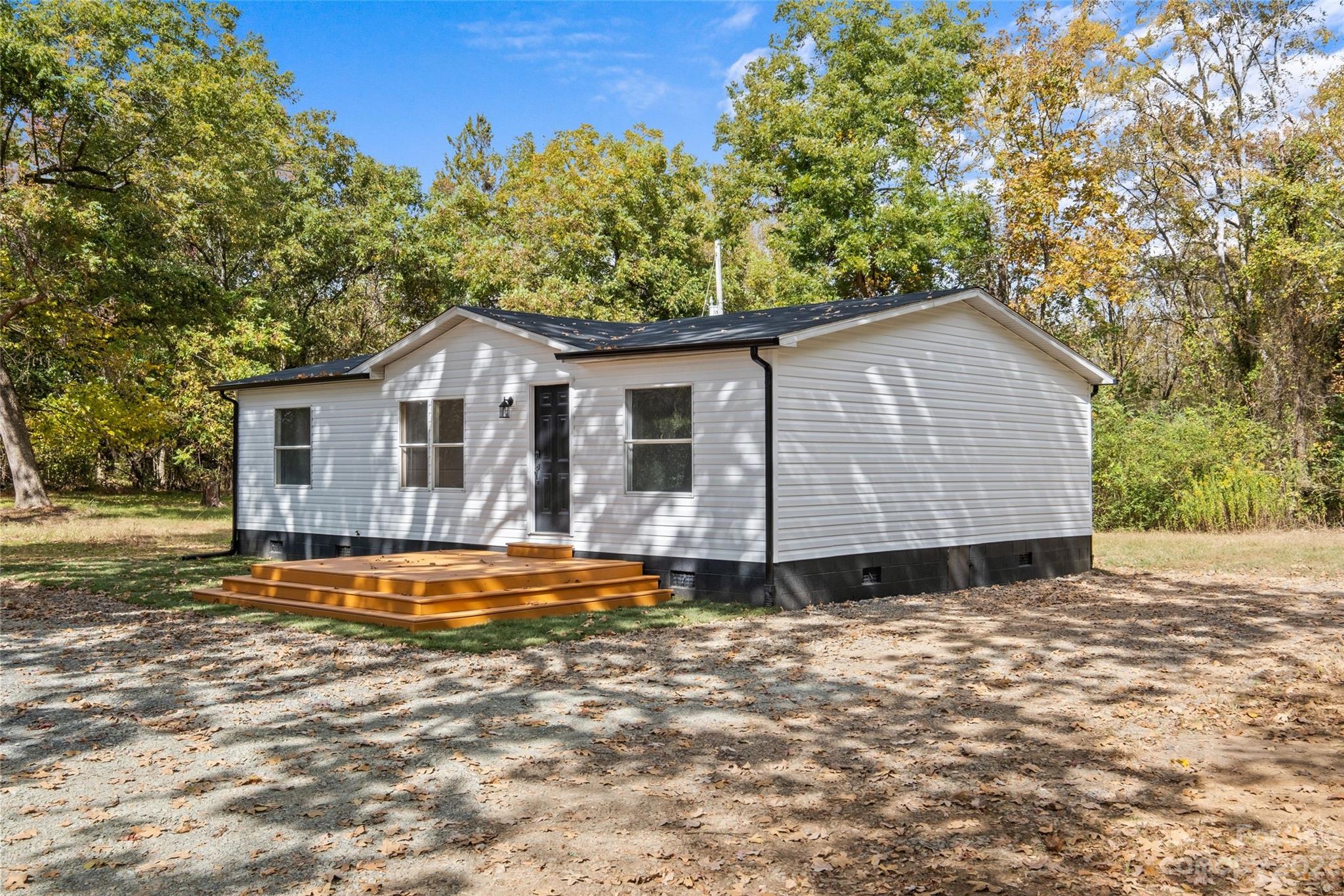 11341 Flowes Store Road Midland, NC 28107 - Photo 3 of 23 a front view of a house with a garden
