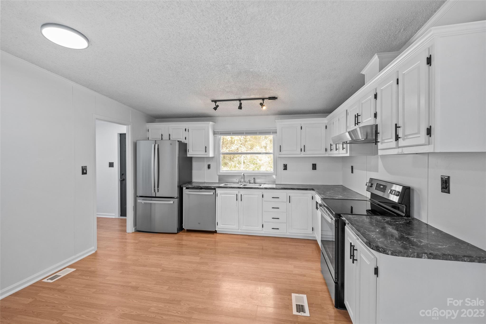 11341 Flowes Store Road Midland, NC 28107 - Photo 8 of 23 a kitchen with granite countertop white cabinets white stainless steel appliances and sink