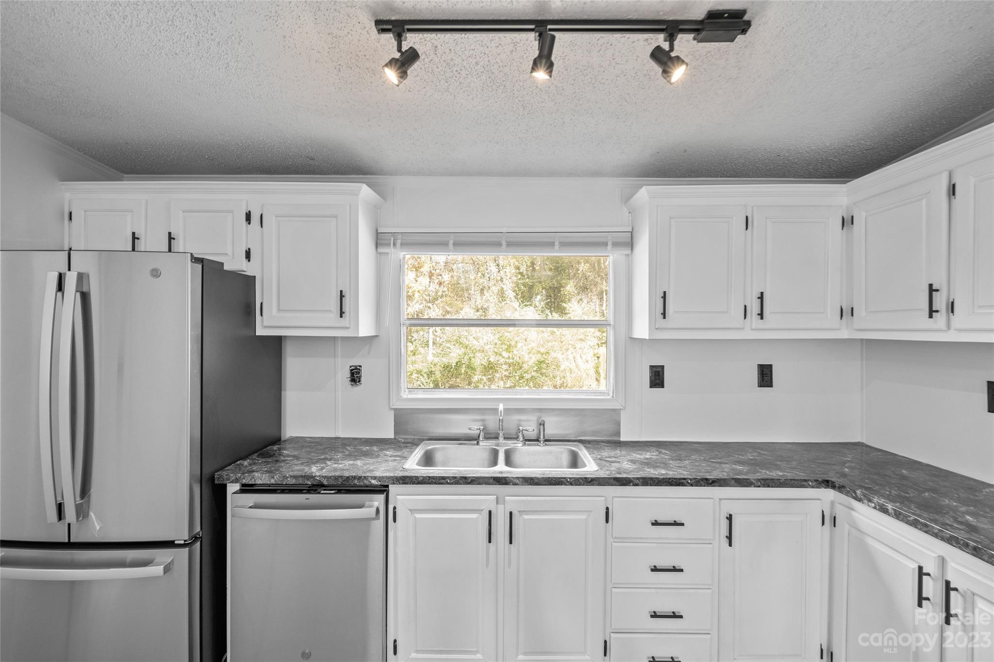 11341 Flowes Store Road Midland, NC 28107 - Photo 10 of 23 a kitchen with granite countertop a white cabinets and refrigerator