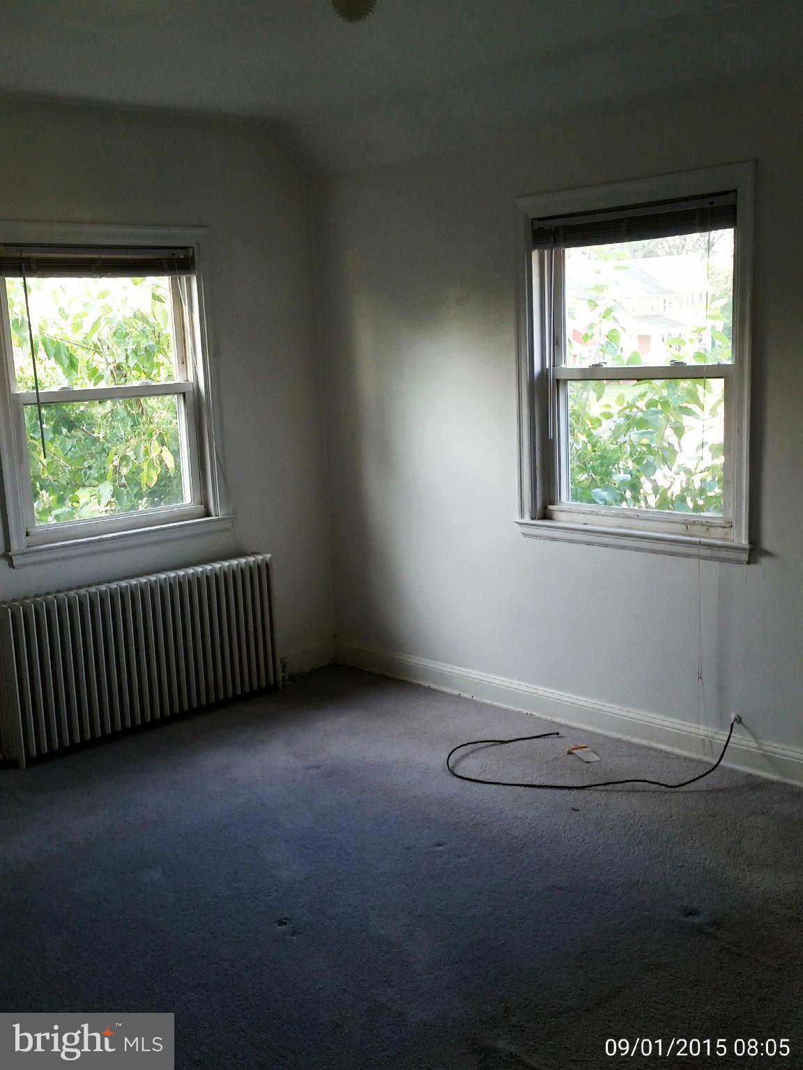 1334 Pentwood Road Baltimore, MD 21239 - Photo 8 of 19 an empty room with wooden floor and windows