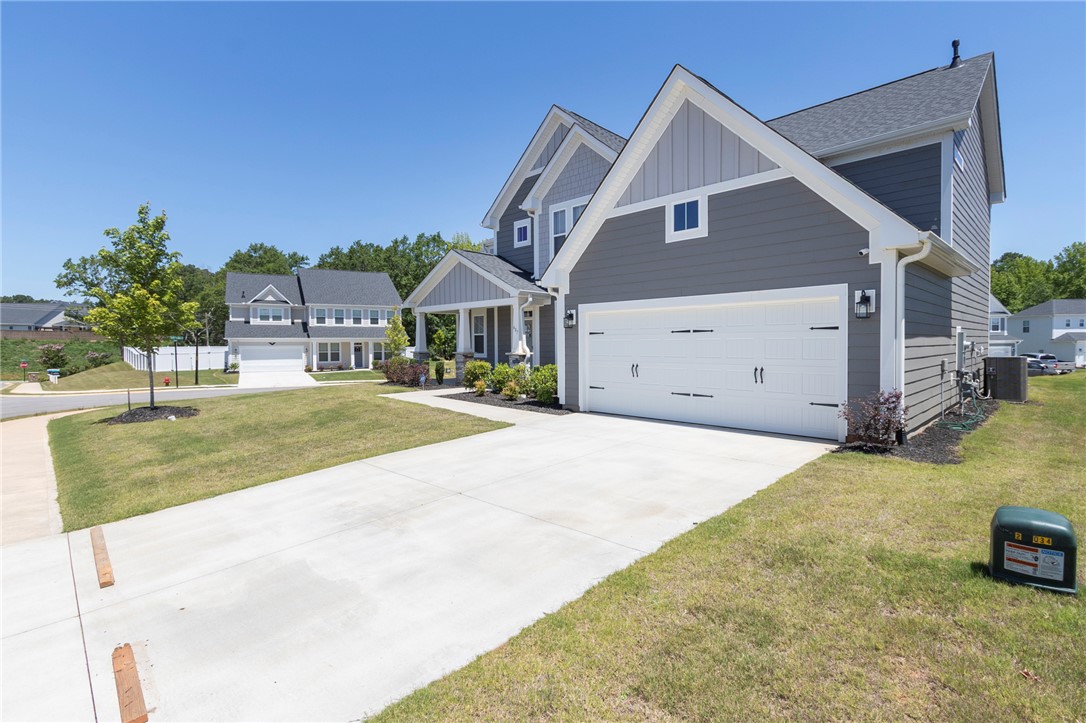 607 WH Kay Lane Anderson, SC 29621 - Photo 44 of 48 A classic gray siding residence with a two-car garage, showcasing a manicured front yard and a paved driveway.