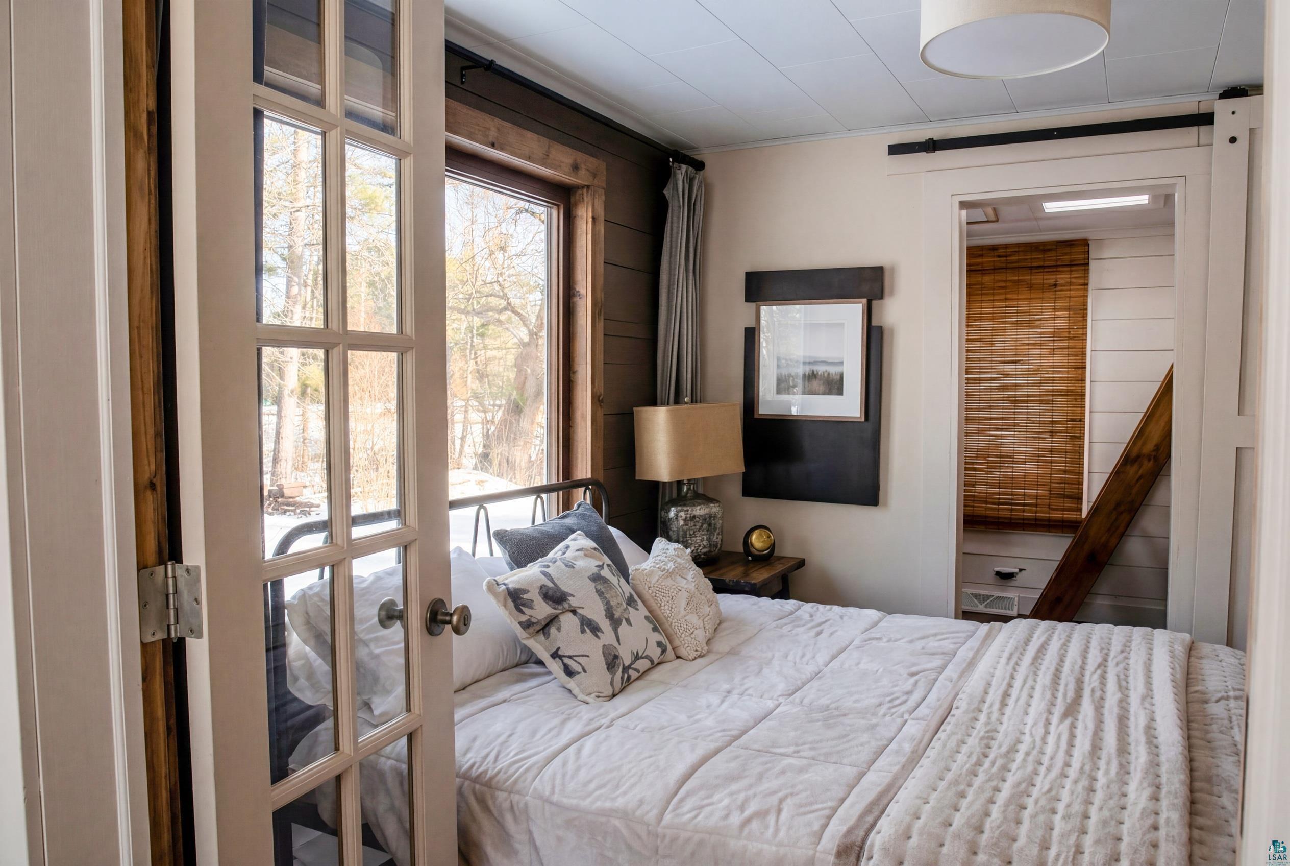 4107 B Lake Park Road Ashland, WI 54806 - Photo 12 of 15 Bedroom with ensuite bath, ornamental molding, and wooden walls