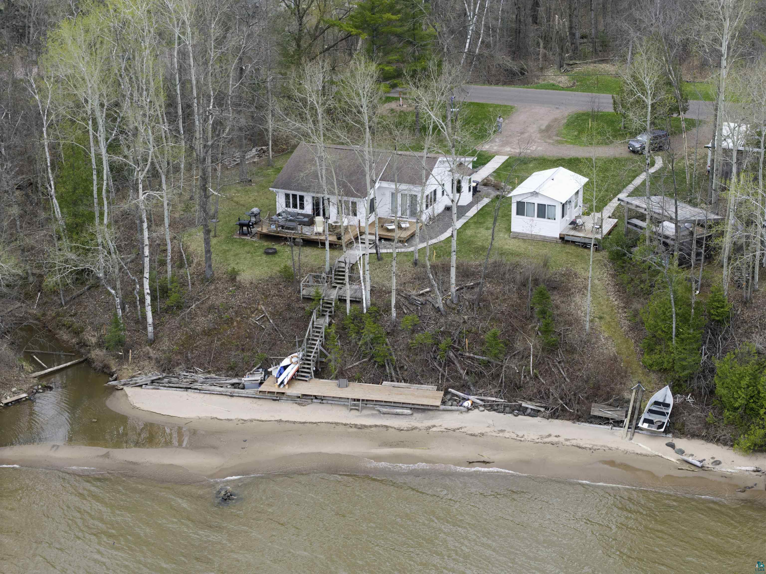 4107 B Lake Park Road Ashland, WI 54806 - Photo 22 of 23 Waterfront property featuring a sandy beach, a private dock, and a multi-level wooden staircase descending from the main residence