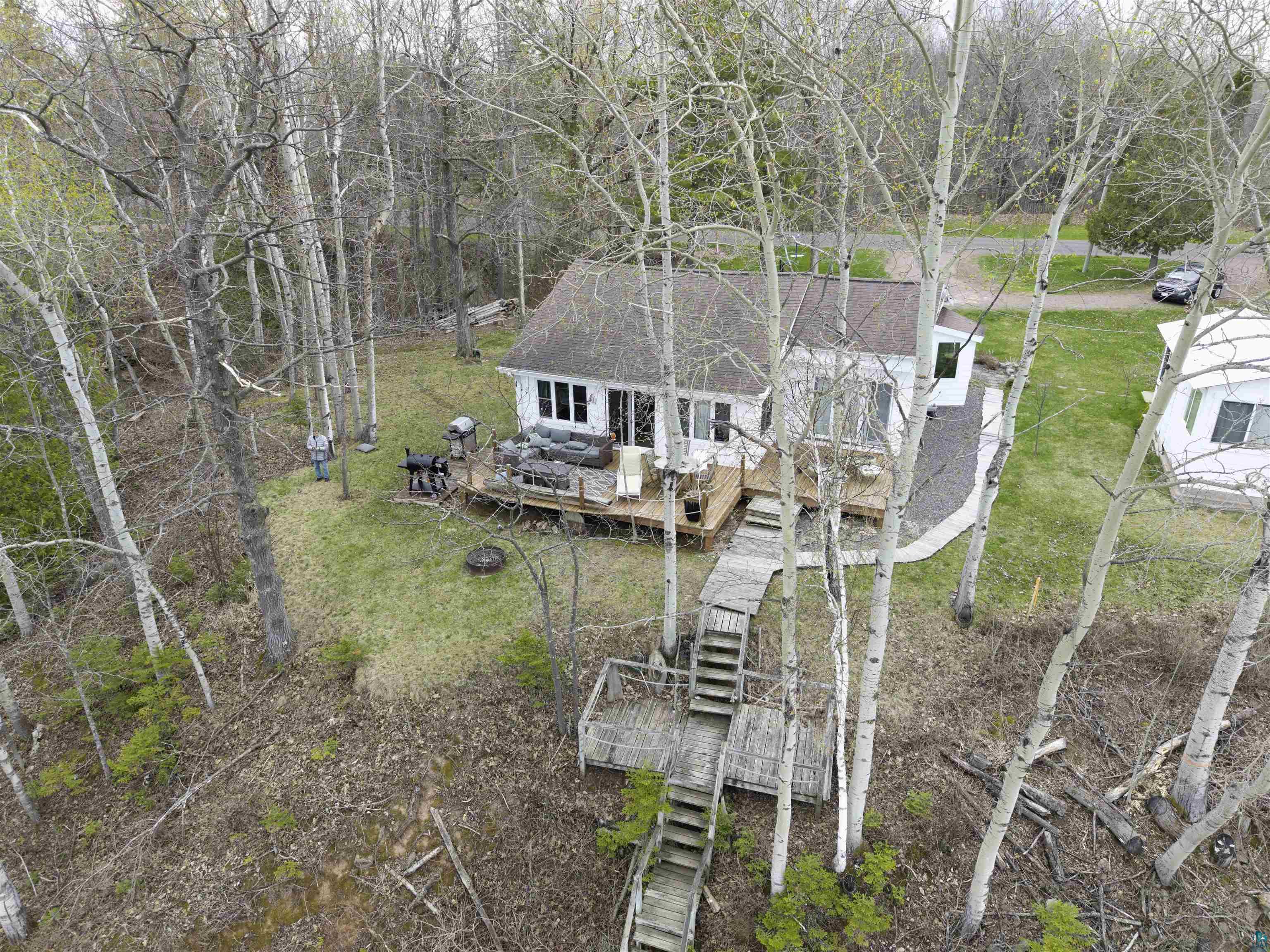4107 B Lake Park Road Ashland, WI 54806 - Photo 3 of 23 White-sided dwelling with a dark roofline, featuring a spacious outdoor deck
