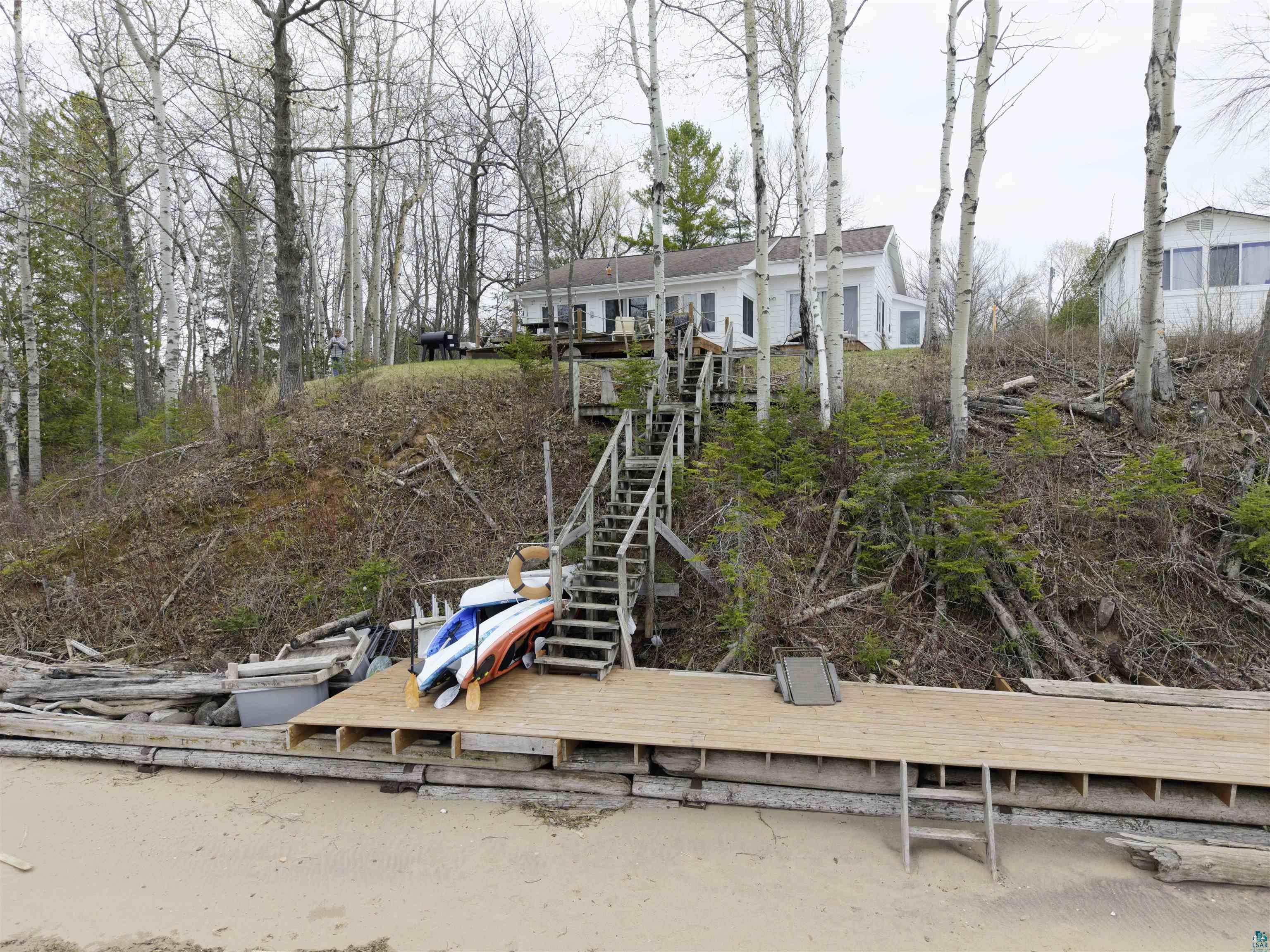 4107 B Lake Park Road Ashland, WI 54806 - Photo 4 of 23 Waterfront property featuring a sandy beach, private dock, and a multi-level staircase providing access to the main residence