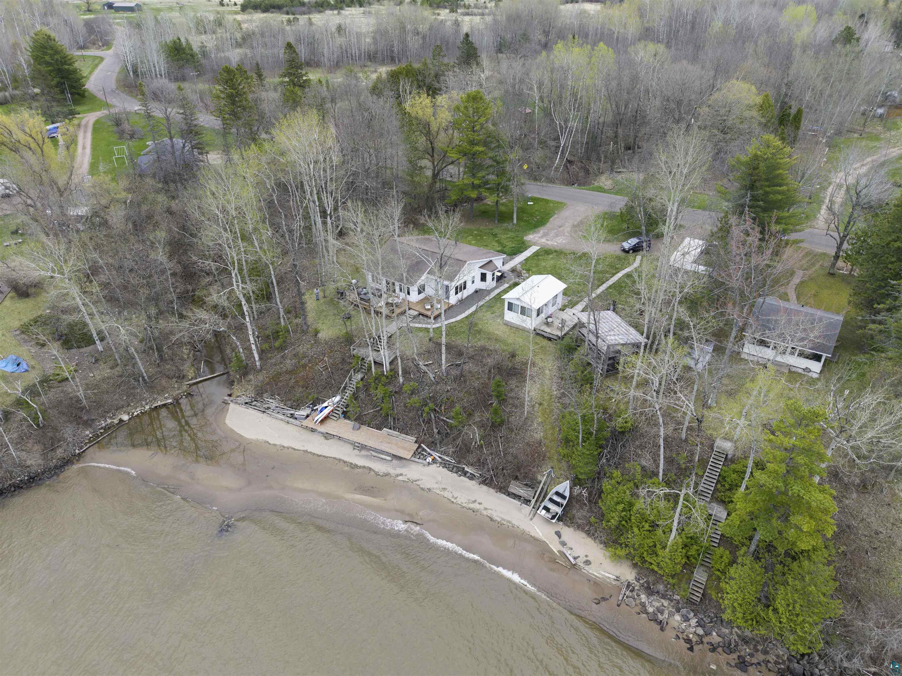 4107 B Lake Park Road Ashland, WI 54806 - Photo 5 of 23 Waterfront property featuring a sandy beach, multiple structures, established trees, and a private dock