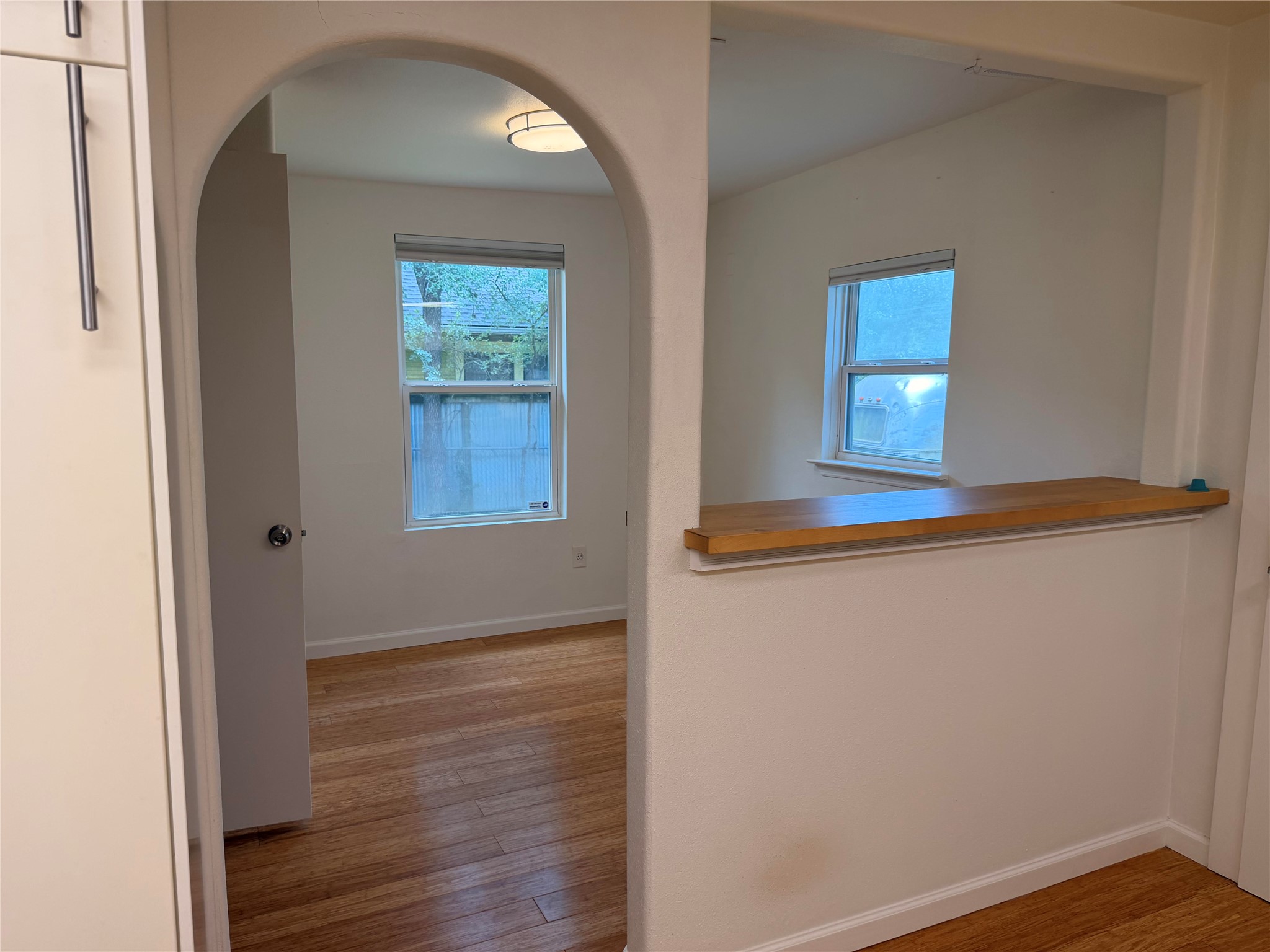 1182 Pandora Street Austin, TX 78702 - Photo 2 of 19 Archways gracefully connect a naturally illuminated space with warm hardwood flooring.