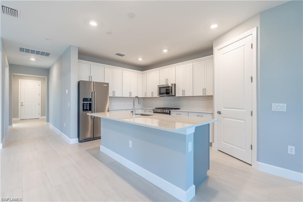 20207 Napa Loop Estero, FL 33928 - Photo 12 of 42 a large kitchen with stainless steel appliances granite countertop a refrigerator and a sink