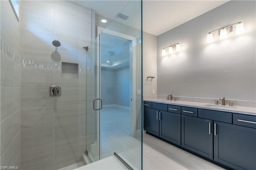 20207 Napa Loop Estero, FL 33928 - Photo 16 of 42 a bathroom with a double vanity sink mirror and shower