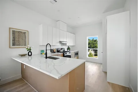 a kitchen with sink cabinets and wooden floor