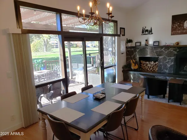 a dining room with wooden floor and a chandelier