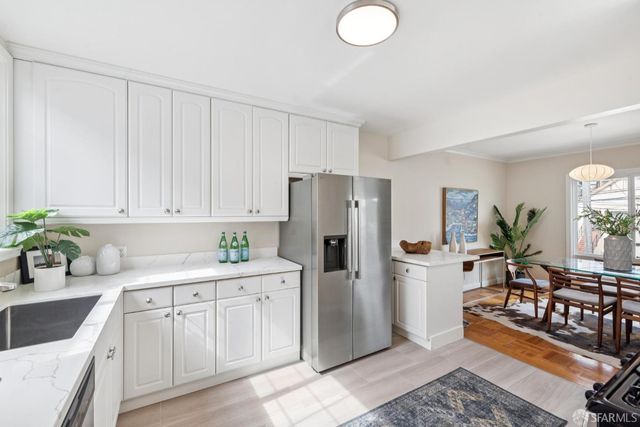 a kitchen with a refrigerator sink and white cabinets