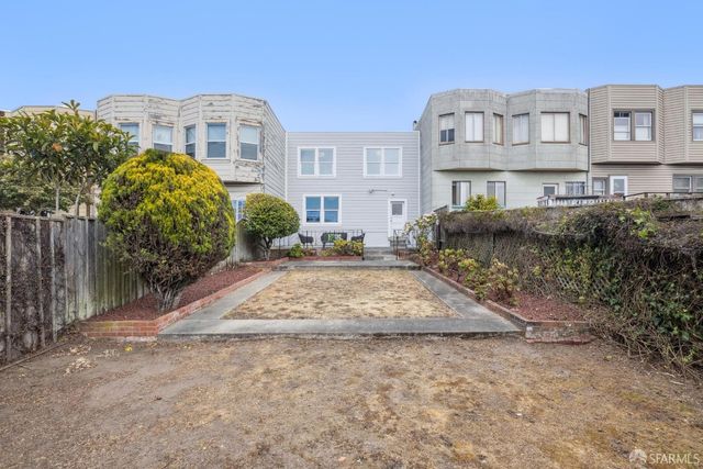 a view of a big house with a yard and plants