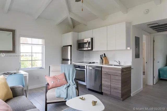 a kitchen with stainless steel appliances granite countertop a stove top oven a sink dishwasher and a microwave oven with white cabinets