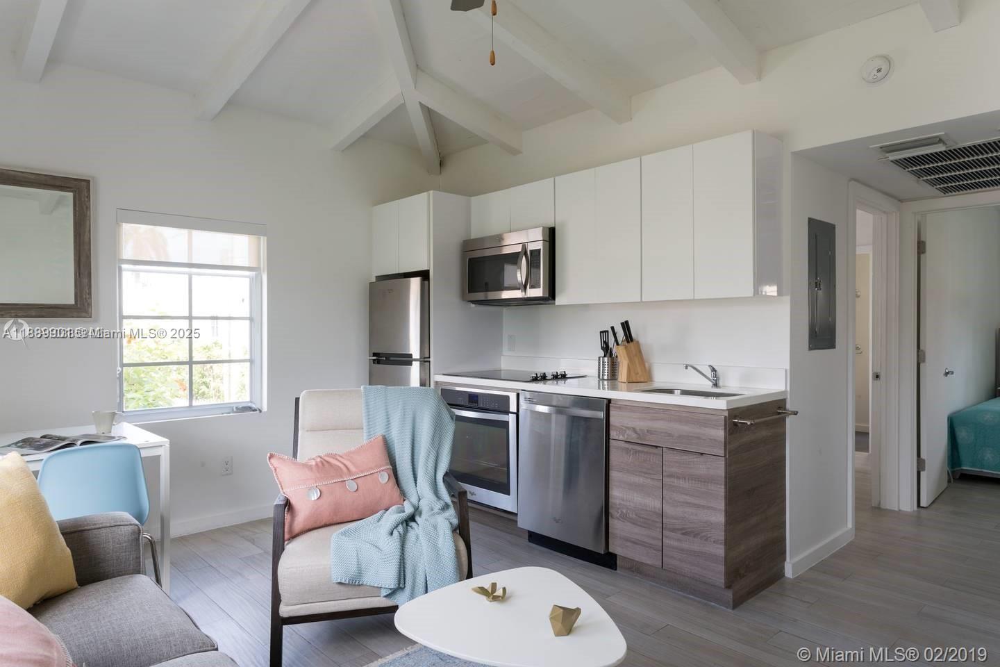 1450 Meridian Avenue, Unit 201 Miami Beach, FL 33139 - Photo 3 of 19 a kitchen with stainless steel appliances granite countertop a stove top oven a sink dishwasher and a microwave oven with white cabinets