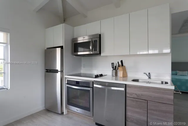 a kitchen with a sink cabinets and stainless steel appliances