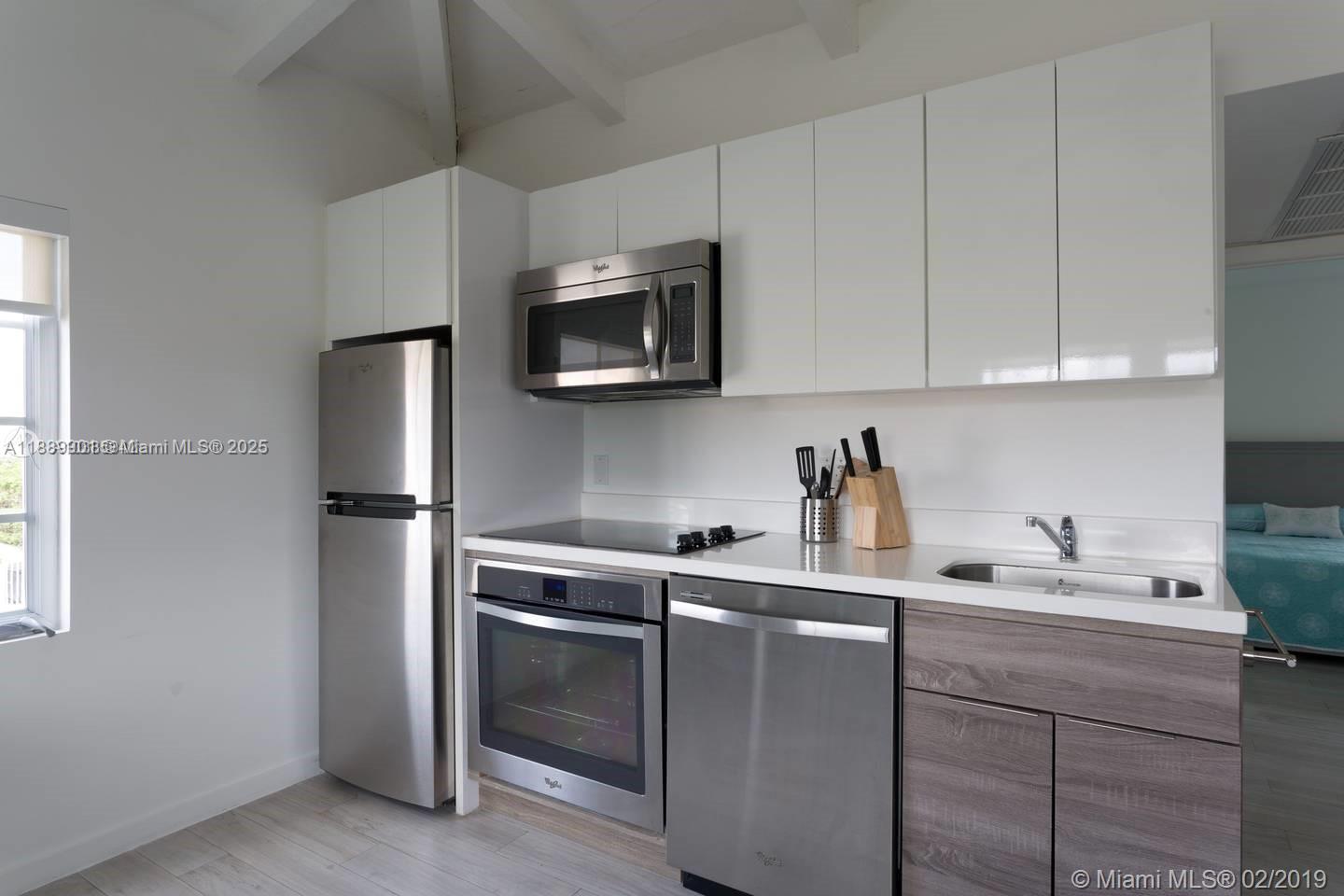 1450 Meridian Avenue, Unit 201 Miami Beach, FL 33139 - Photo 6 of 19 a kitchen with a sink cabinets and stainless steel appliances