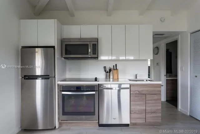 a kitchen with cabinets stainless steel appliances and sink