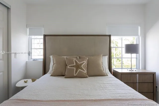 a large bed sitting in a bedroom next to a window