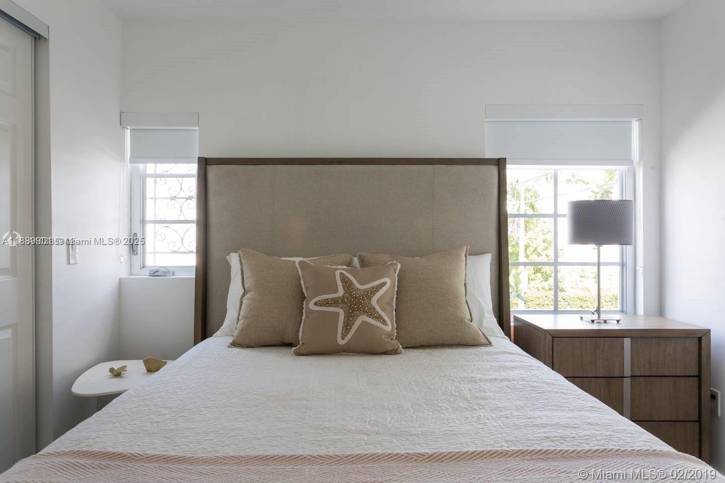 1450 Meridian Avenue, Unit 201 Miami Beach, FL 33139 - Photo 10 of 19 a large bed sitting in a bedroom next to a window