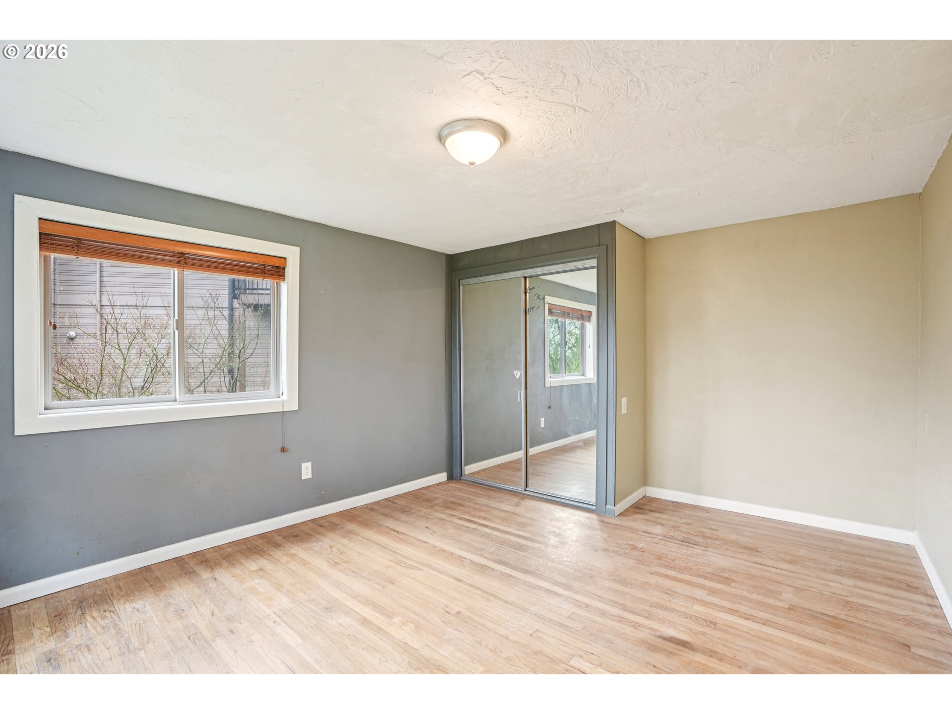 12444 Southwest 57th Avenue Portland, OR 97219 - Photo 23 of 44 a view of an empty room with wooden floor and a window
