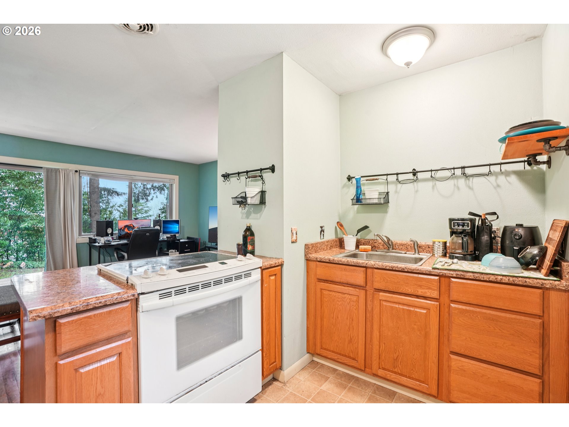 12444 Southwest 57th Avenue Portland, OR 97219 - Photo 32 of 44 a kitchen with a stove a sink and a refrigerator