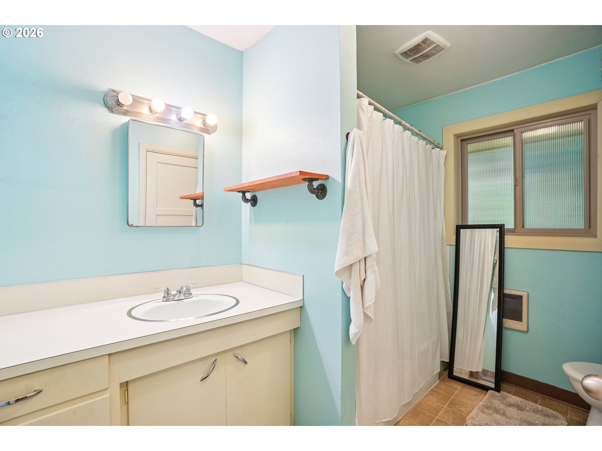 12444 Southwest 57th Avenue Portland, OR 97219 - Photo 35 of 44 a bathroom with a sink mirror toilet and vanity
