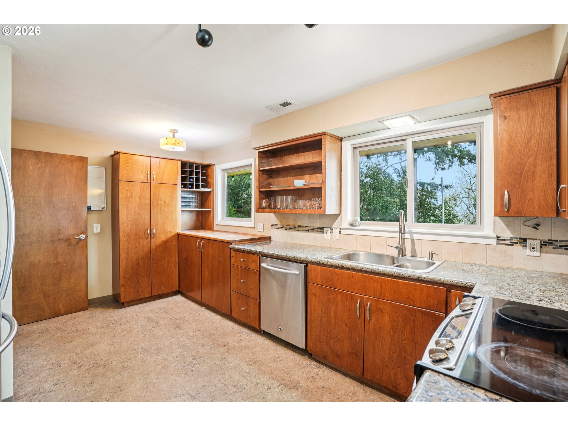 12444 Southwest 57th Avenue Portland, OR 97219 - Photo 8 of 44 a kitchen with stainless steel appliances granite countertop a sink stove and refrigerator