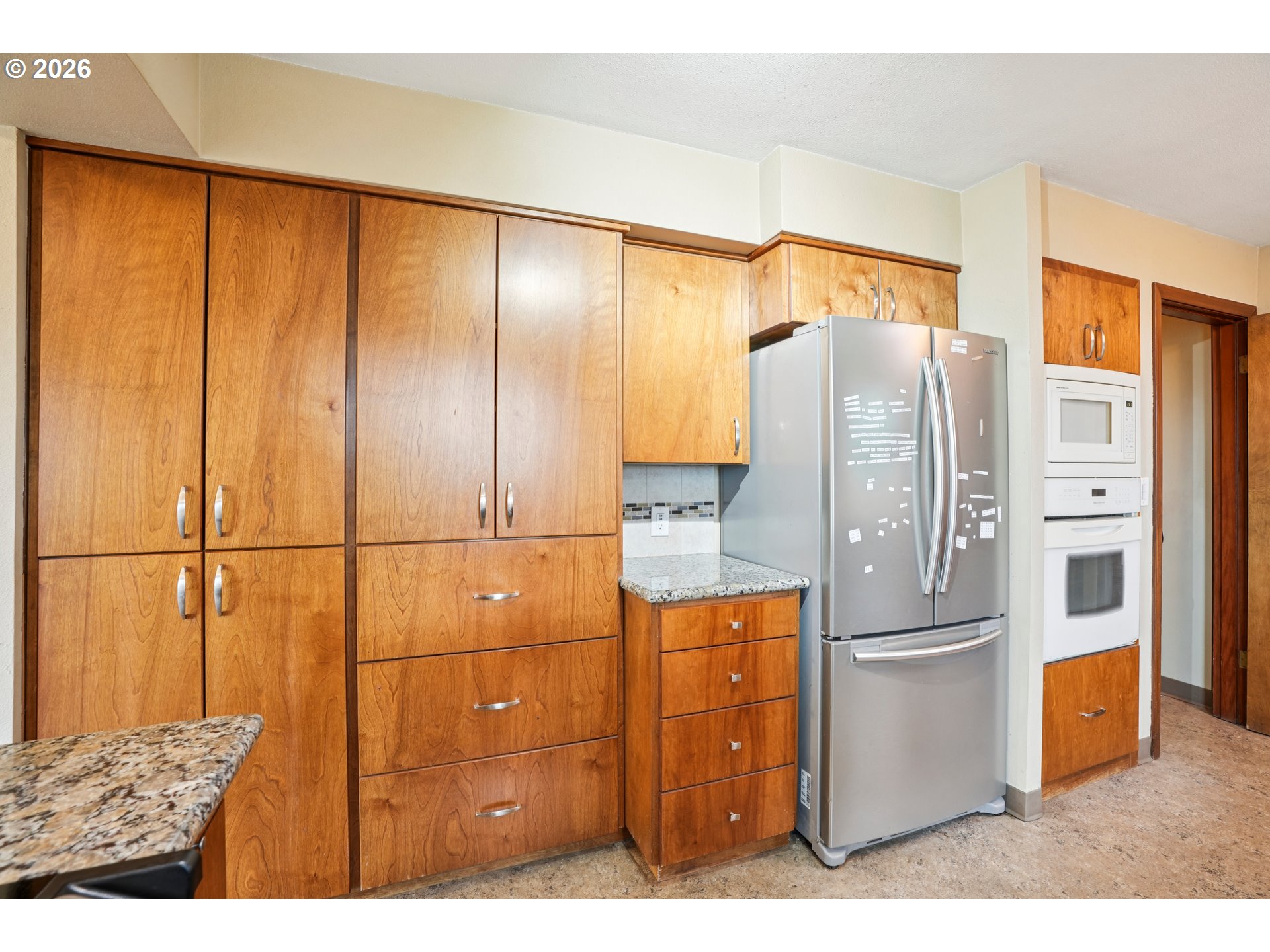 12444 Southwest 57th Avenue Portland, OR 97219 - Photo 9 of 44 a kitchen with stainless steel appliances granite countertop a refrigerator and cabinets