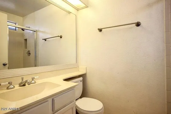 a bathroom with a sink mirror vanity and toilet