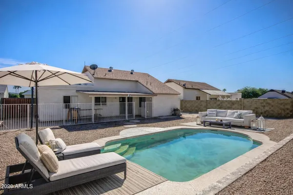 a view of a house with a backyard and sitting area