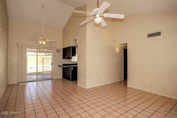 a view of a livingroom with a chandelier fan and windows