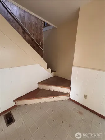 a view of a room with stairs and white walls
