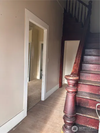 a view of entryway and hall with wooden floor