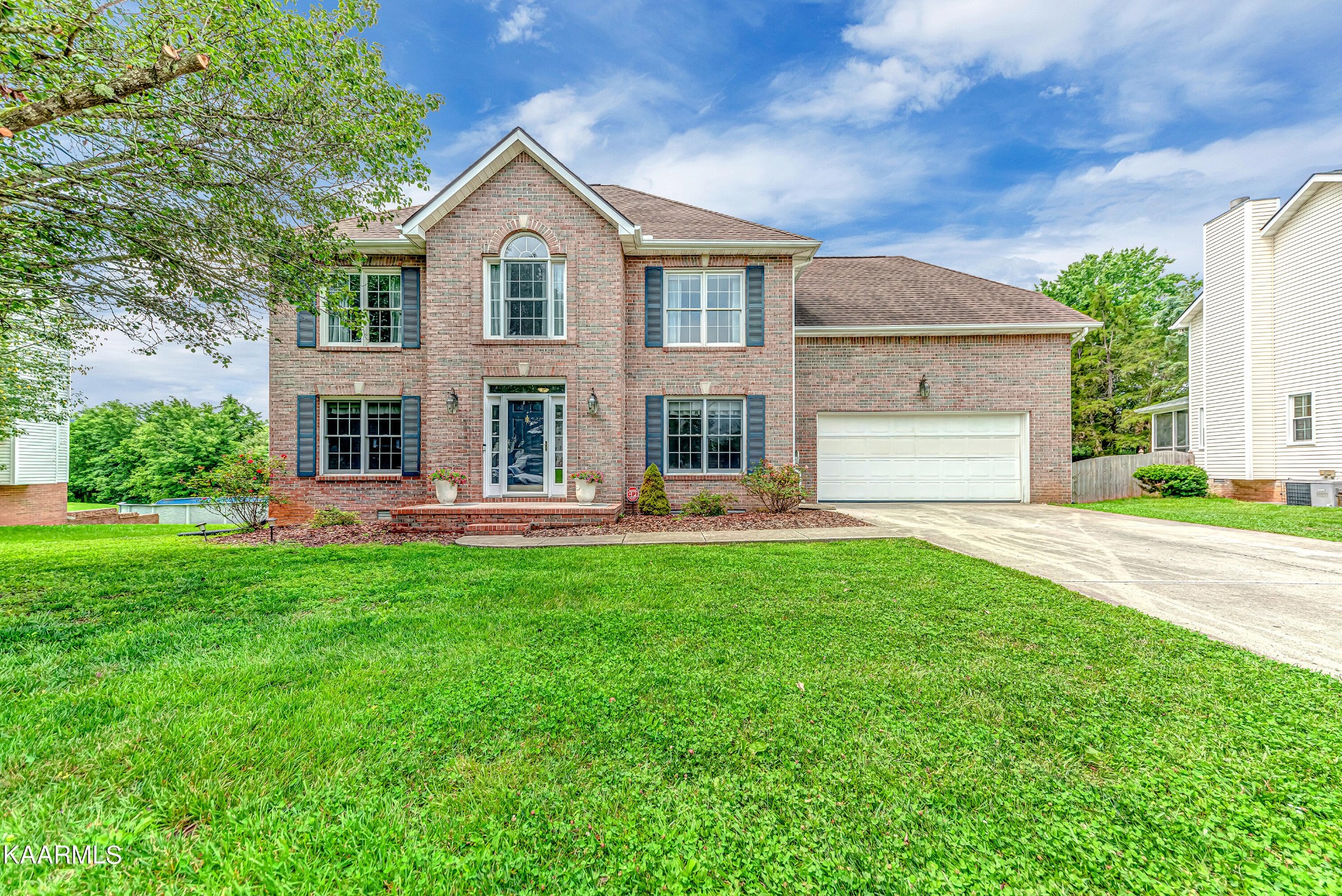a front view of a house with yard and green space