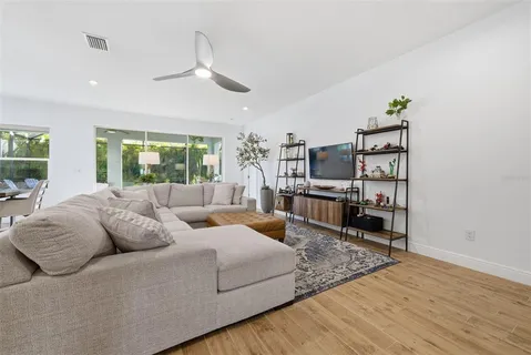a kitchen with kitchen island sink stove and white cabinets with wooden floor