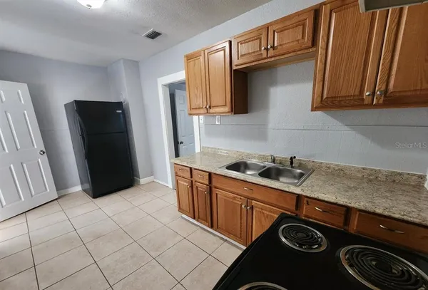 a kitchen with stainless steel appliances granite countertop a refrigerator and a sink