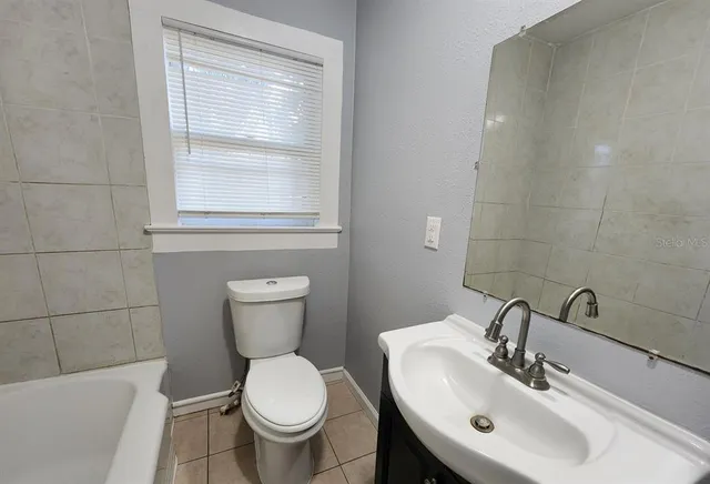 a bathroom with a sink toilet and a mirror