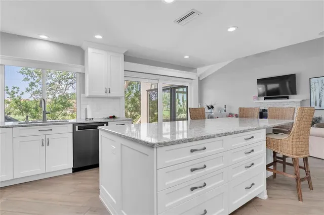 a kitchen with granite countertop white cabinets and white appliances