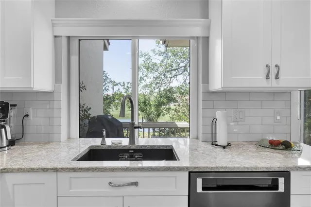 a kitchen with granite countertop a sink and a stove
