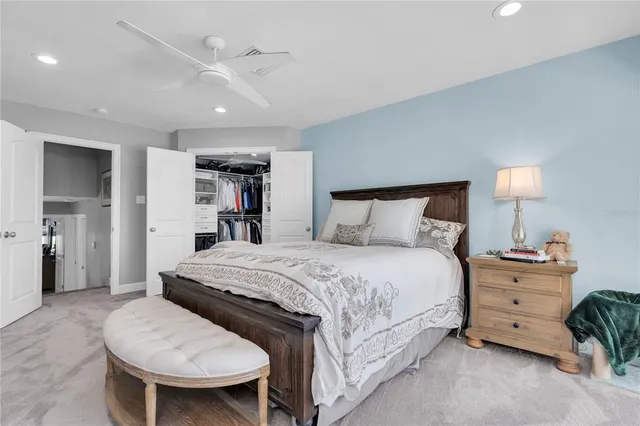 a spacious bedroom with a bed and a lamp