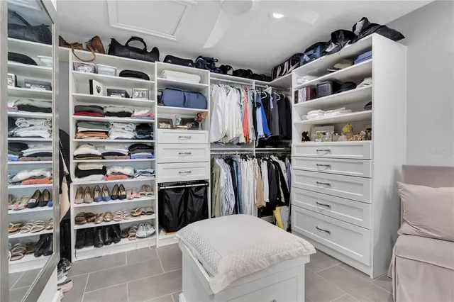a view of walk in closet with clothes and shoes