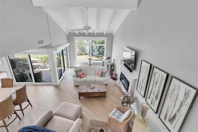 a living room with furniture large window and wooden floor