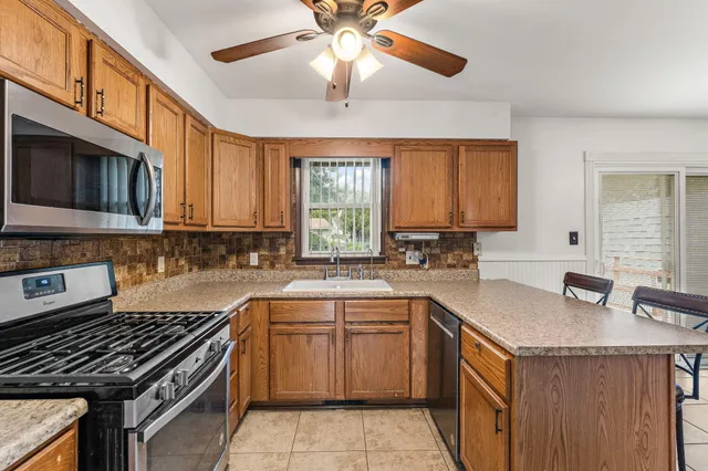 a kitchen with a sink stove top oven and cabinets
